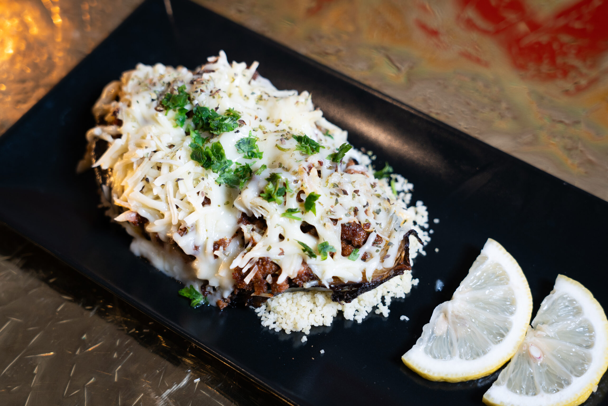 BERENJENA RELLENA CON CARNE PICADA SOBRE BASE DE COUS COUS scaled